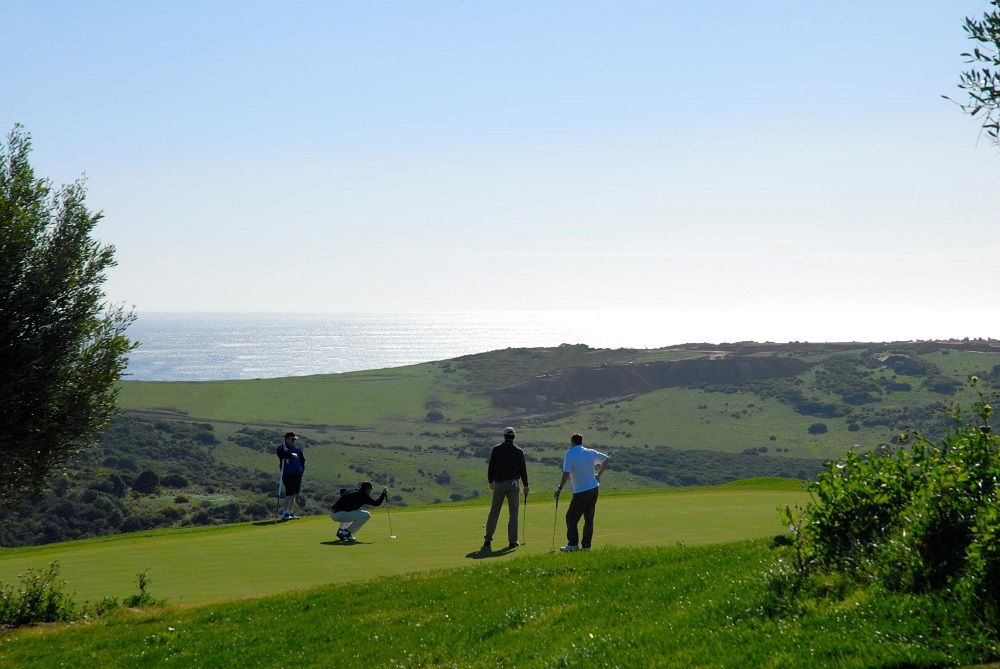 Golfeurs en action sur le fairway de Finca Cortesin, et mer à l'arrière plan