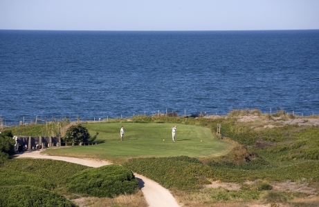 Golfeurs sur le départ du golf Parador del Saler avec vue sur la mer
