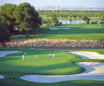 Golfeurs sur le green entouré de bunkers sur le parcours La Manga Club